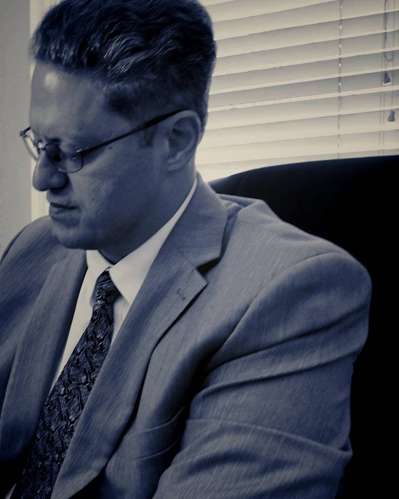 Salah George Alhanna at his desk — graded still from firm footage